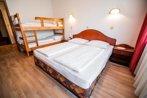 a bedroom with a bed and a bunk bed at Guesthouse Leski Dvor in Lesce