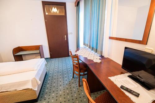 a hotel room with a bed and a desk with a computer at Guesthouse Leski Dvor in Lesce