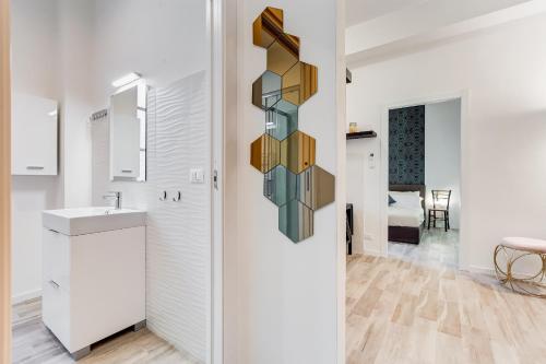 biała łazienka z umywalką i lustrem w obiekcie BDC - Termini Sun Apartment w Rzymie