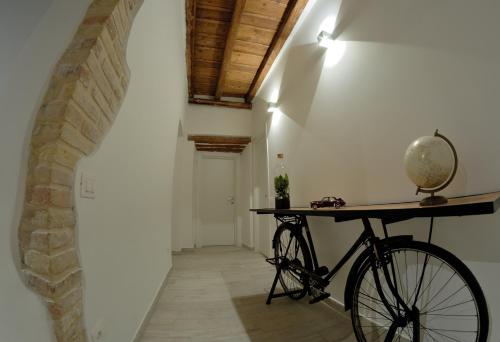 a bike parked in a hallway with a brick wall at B&B DEL CORSO in Loreto
