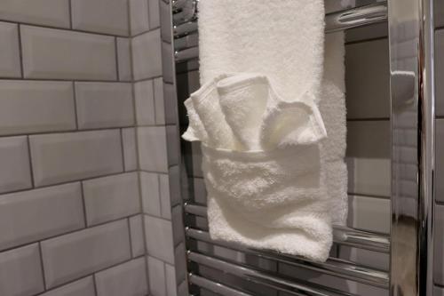 - une serviette suspendue à un porte-serviettes dans la salle de bains dans l'établissement The Bridge Inn Hotel, à Bolton