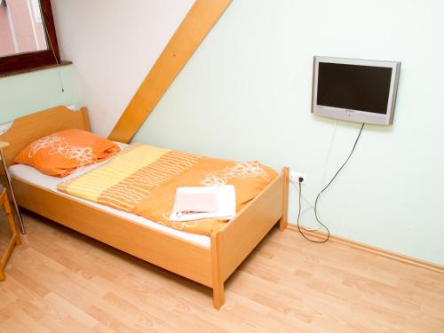 a bedroom with a bed with a tv on the wall at Guest House Pri Treh Lipah in Ptuj