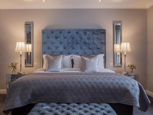 1 dormitorio con 1 cama grande y cabecero azul en The Ashe Hotel en Tralee