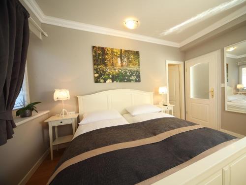 a bedroom with a bed and a painting on the wall at Vila Edelweiss Rooms&App Kranjska Gora in Kranjska Gora
