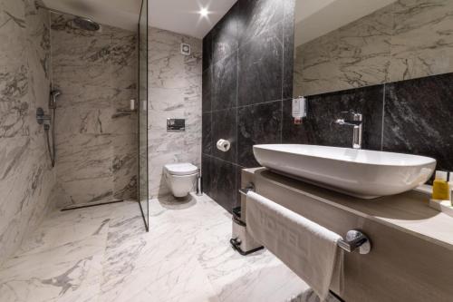 y baño con lavabo, ducha y aseo. en Hotel Berane en Berane