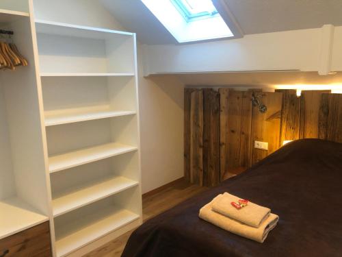 a bedroom with white shelves and a bed and a skylight at Landhaus Kössel in Füssen