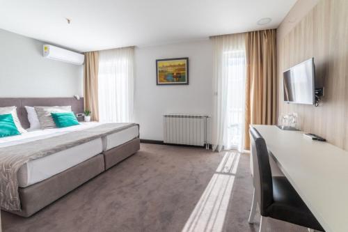 a bedroom with a large bed and a television at Hotel Berane in Berane