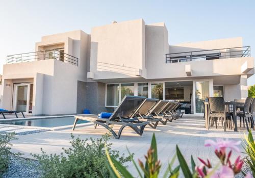 a villa with a swimming pool and lounge chairs at Villa Bonita Brenda by Algarve Vacation in Armação de Pêra