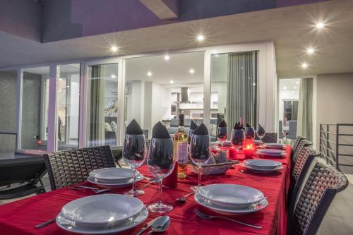 a dining room table with plates and wine glasses at Villa Bonita Brenda by Algarve Vacation in Armação de Pêra