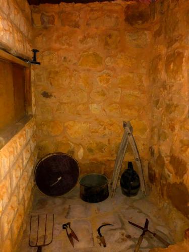 a painting of a room with tools in a stone wall at The Orient Home in Wadi Musa
