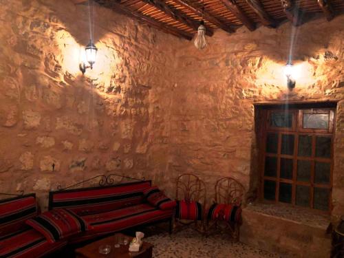 a room with two red benches in a stone wall at The Orient Home in Wadi Musa