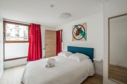 een slaapkamer met een wit bed en een rood raam bij Bright and cosy flat at the heart of Paris in a trendy district - Welkeys in Parijs