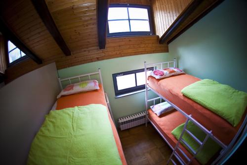 two bunk beds in a small room with two windows at Hostel Samobor in Samobor