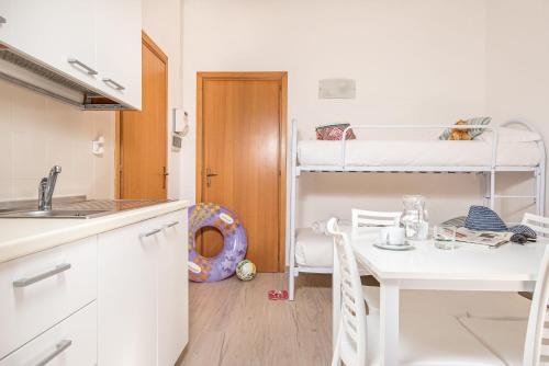 a small kitchen with a table and a bunk bed at Villaggio Orizzonte in Riotorto