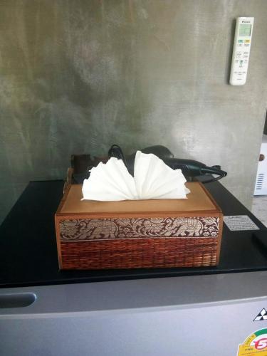 a wooden box with white tissues in it on a table at T&P at Pai in Pai