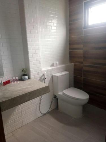 a white bathroom with a toilet and a sink at T&P at Pai in Pai