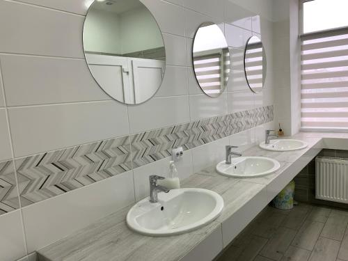 a bathroom with two sinks and two mirrors at Good Rest in Chemerivtsi