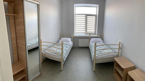 a small room with two beds and a mirror at Good Rest in Chemerivtsi