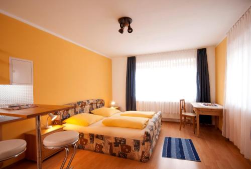 1 dormitorio con cama, escritorio y ventana en Hotel Hottentotten, en Regensburg