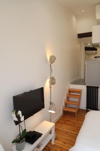 une chambre avec un lit et une télévision sur une table dans l'établissement La Terrasse de Wilson, à Toulouse