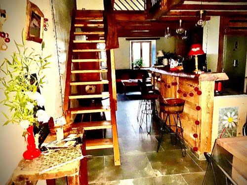 salon ze spiralnymi schodami i kuchnią w obiekcie Ferme familiale chez Lili w mieście Alex