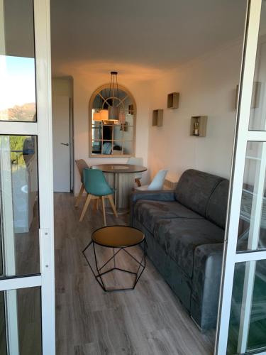 un salon avec un canapé et une table dans l'établissement SAINT RAPHAEL, CAP ESTEREL Le Hameau. Vue mer, à Saint-Raphaël
