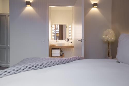 a bedroom with a white bedspread and white pillows at Bella vista in Valkenburg