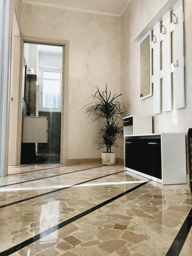 a living room with a potted plant on the floor at Ylli House Sanremo in Sanremo