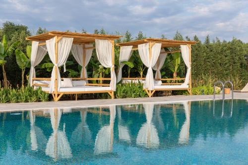a pool with two chairs and a gazebo at Zigo's Hotel in Mugla