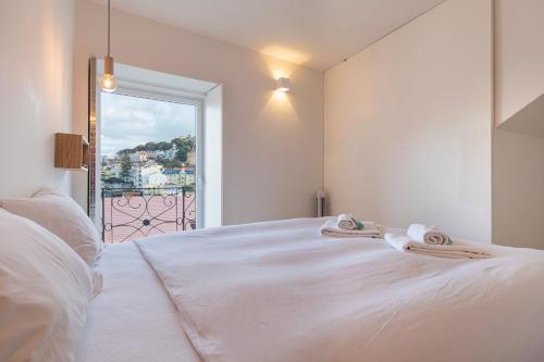 een wit bed met twee handdoeken erop bij LovelyStay - Lisbon Home With Castle View in Lissabon