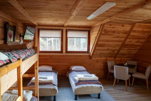 a room with two bunk beds in a cabin at Domek Górski przy Bukowej Chacie in Jugów