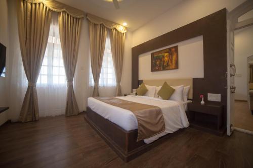 a bedroom with a large bed in a room at Regenta Place Green Leaf Mahabaleshwar in Mahabaleshwar
