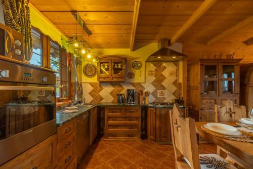 a large kitchen with wooden cabinets and a table at Widokowa Górka in Czerwienne