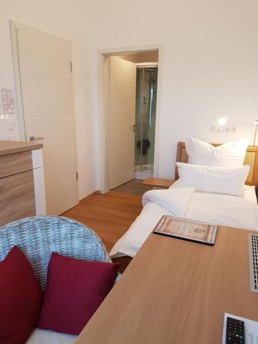 a room with two beds and a desk with a laptop at Gästehaus Staudenschloss in Mickhausen