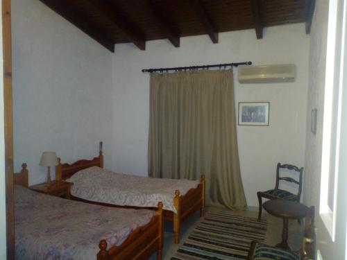 1 Schlafzimmer mit 2 Betten und einem Stuhl in der Unterkunft Sunhouse Vrachati in Vrachati