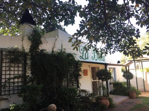 a white building with a green sign on it at La Bella B&B Under The Fig Tree in Bela-Bela
