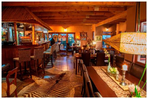 a restaurant with tables and chairs and a bar at Thali Thali Game Lodge in Langebaan