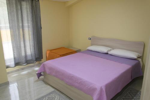 a bedroom with a purple bed and a window at Stella d'Oro in Vibo Valentia