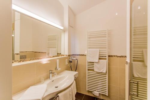 a bathroom with a sink and a mirror at Gasthof Bräuer - Familie Eibensteiner in Weißkirchen in Steiermark