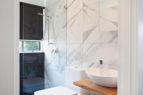 a white bathroom with a sink and a shower at Woolwich Studio Bliss, Private Oasis by the Water in Sydney