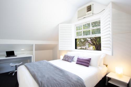 um quarto com uma cama branca e uma janela em Woolwich Studio Bliss, Private Oasis by the Water em Sydney