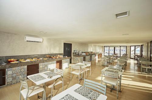 a restaurant with tables and chairs and a bar at Moriah Natal Beach Hotel in Natal