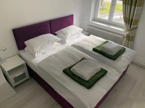ein Schlafzimmer mit einem großen Bett mit zwei Kissen in der Unterkunft Feathers Apartments in Hermagor