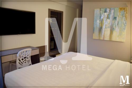 a hotel room with a white bed and a tv at Hotel Mega in Lima