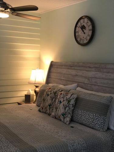 a bedroom with a clock on the wall at SeaGlass Inn Bed and Breakfast in Melbourne Beach