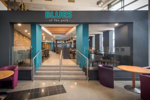 a lobby of a restaurant with purple chairs and tables at The Park Hotel in Kilmarnock