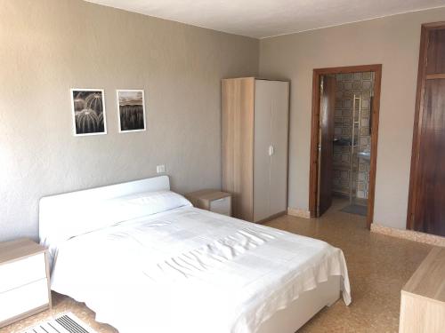 sypialnia z białym łóżkiem i lustrem w obiekcie Villa tosalet w mieście Jávea