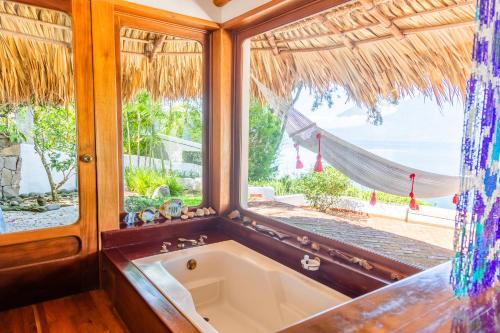 eine Badewanne in einem Zimmer mit Meerblick in der Unterkunft Tzampoc Resort in Santa Catarina Palopó