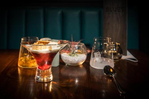 a wooden table with three glasses and a spoon at The Park Hotel in Kilmarnock