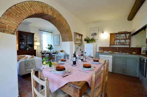 a kitchen with a table with a pink table cloth at Petrolo in Bucine